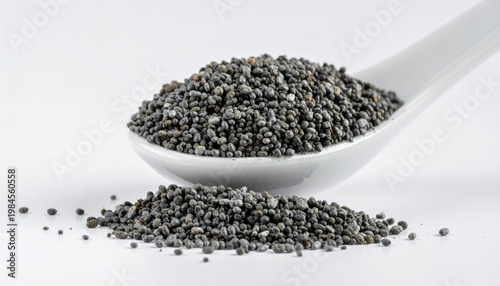 Dark Poppy Seeds Piled on a White Spoon and Surface, Isolated Macro Detail