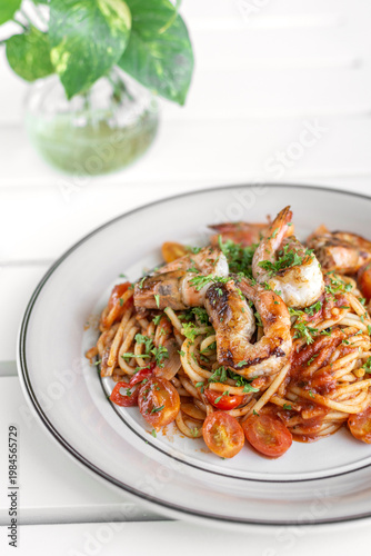 shrimp and tomato diavolo spicy spaghetti on white table at outdoor restaurant in italy