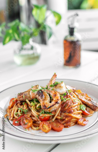 shrimp and tomato diavolo spicy spaghetti on white table at outdoor restaurant in italy