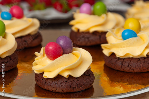 brown cookies with yellow cream and candies