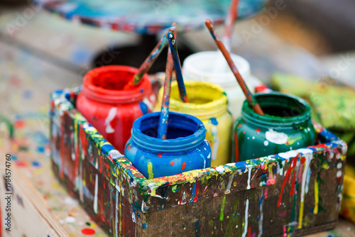 Colorful Paint Jars With Brushes In Creative Studio