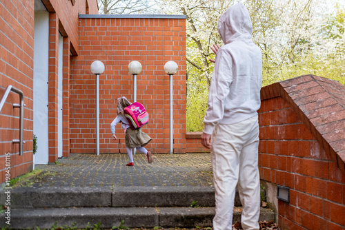Fotografie man in white suit watching young girl school entrance from distance, attention u