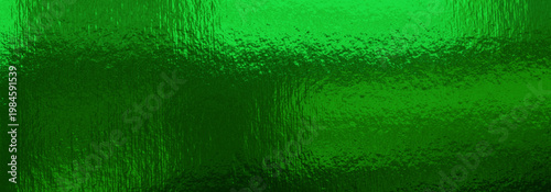 Shiny green gold metallic surface with reflective textured foil, creating a l...
