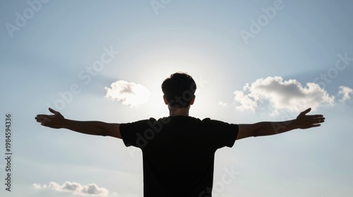 Silhouette of Person with Outstretched Arms Against Bright Sky