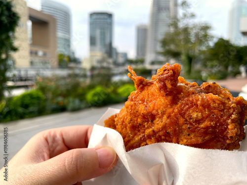 Wallpaper Mural フライドチキン ─ 手持ちの骨付きチキン・都市背景の屋外 Torontodigital.ca