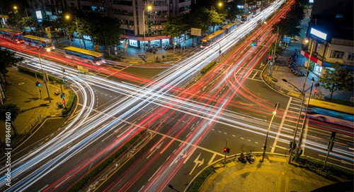 Busy city intersection at night with light trails from traffic.