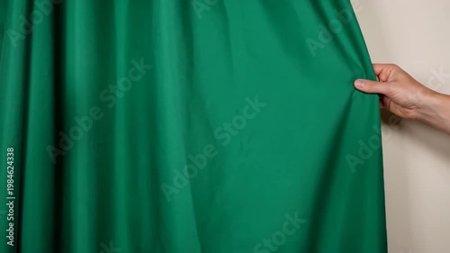 Pulling down a chroma key green screen curtain 
