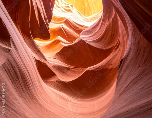 Curving sandstone walls, shot upwards, lit by a golden, hazy light