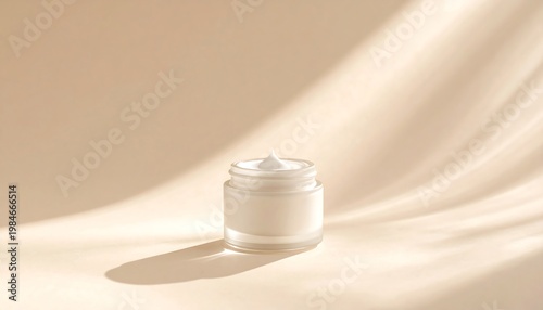 A glass jar of white cream on a beige fabric background with soft lighting