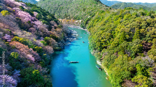 Boatman punting the boat at river. Arashiyama in spring season along the river in Kyoto, Japan.