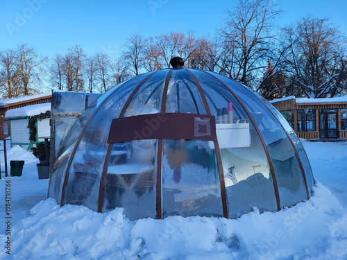 Glass dome transparent igloo gazebo on a snowy square