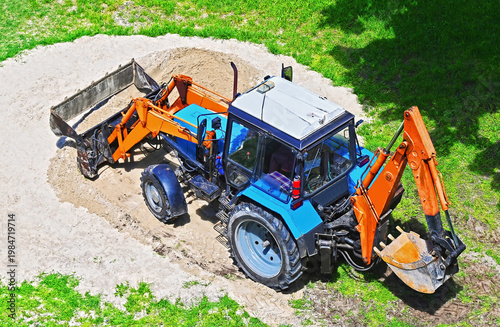 Excavator-loader working with sand