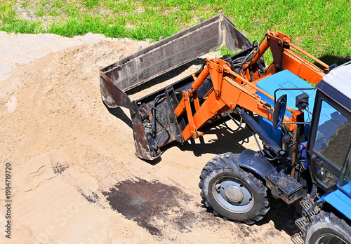 Excavator-loader loading sand