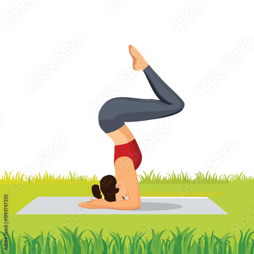Woman practicing yoga in headstand pose on a mat in a grassy meadow