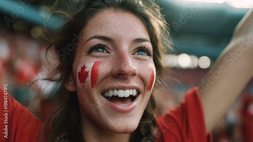 Euphoric woman in a football stadium with her face painted with the colors of the Canadian flag, cheering and supporting her team.