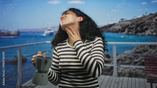 Foto Woman clutching her neck while holding a stovetop coffee maker on a beach pier; discomfort health concern