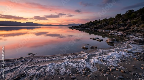 Wallpaper Mural Serene lake reflecting colorful sunset sky over distant mountains and rocky shore during twilight Torontodigital.ca