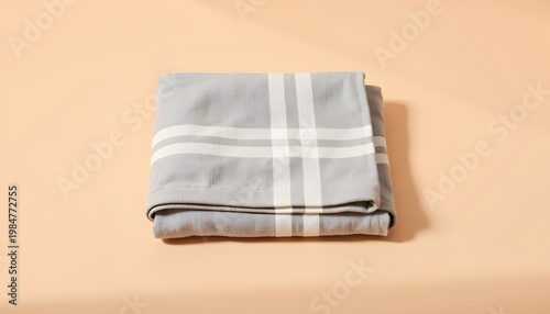Soft gray picnic blanket on sand-colored background, minimalist aesthetics