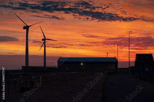 Wind turbines and port buildings at Shoreham Port at dusk
