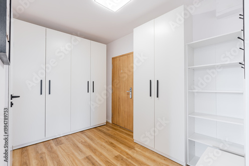 Modern hallway featuring white built in wardrobes and minimalist design
