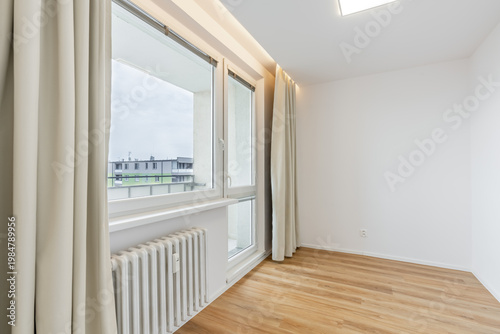 Empty room presenting minimalist interior design with window and hardwood floor