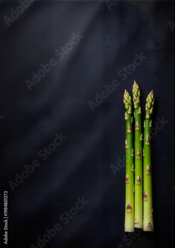 Fresh green asparagus stalks on dark background for Health Day  