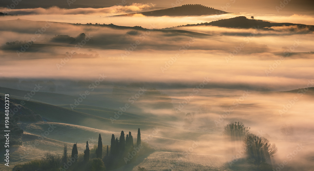 Fototapeta premium Morning fog covering Val d'Orcia hills at sunrise, Italy.