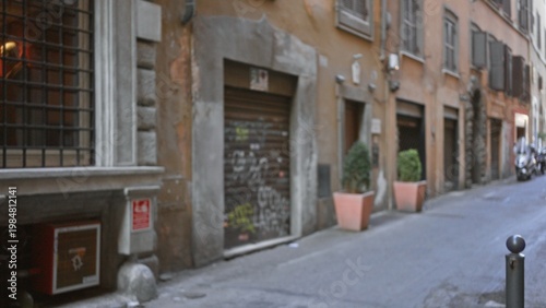 Narrow rome street scene rendered soft and defocused with warm building facades, planters and shutters in shallow bokeh; background copyspace.
