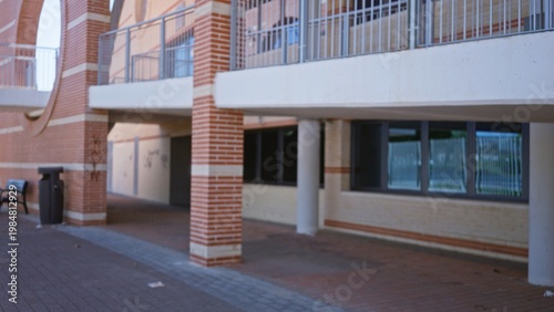 Tableau sur toile Defocused brick building walkway with pillars, balconies and windows, soft shallow blur building; background copyspace backplate calm