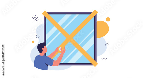 Man applying large pieces of yellow adhesive tape in a cross pattern on a glass window to prepare for an approaching storm or hurricane.