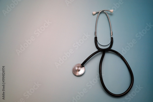 Foto Professional black stethoscope beautifully placed on a soft blue and white gradient background, creating a clean and minimalistic medical composition