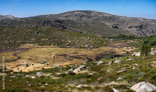 Vallée du massif montagneux portugais de la Serra da Estrela dans le centre du Portugal. Vallon aride et pierreux où paissent des moutons entre les côteaux secs et rocailleux.