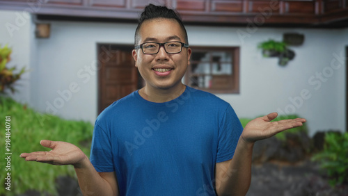 Картината върху платно Man shrugging with palms up at building entrance wearing blue shirt and glasses, looking puzzled; uncertainty question openness