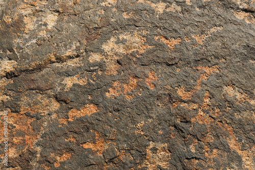 Tableau sur toile Dark volcanic rock texture with rugged surface and irregular mineral shapes