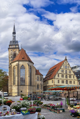 View of Schillerplatz square with Stiftskirche in Stuttgart, Germany. Historical church and flower market under cloudy sky