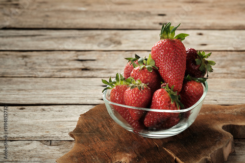 Fresh Strawberries in a Glass Bowl on a Wooden Table