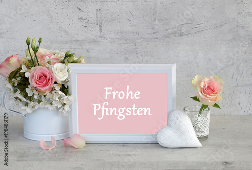 Grußkarte Frohe Pfingsten: Stillleben mit weißem Herz,Rosen und  Schriftzug Frohe Pfingsten.
