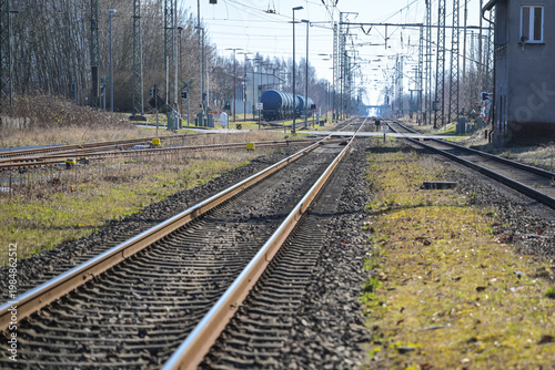 Rail tracks, overhead wires, and a tanker train at a rural station, concept for travel, public transit and transportation, selected focus