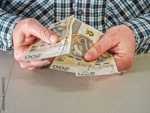 Close up of businessman hands holding stack of Polish Zloty paper money for commercial transaction