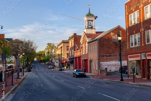 Scenic view of North Market Street in historic Frederick, Maryland, featuring the vintage brick fire station with a bell tower under a clear sky.