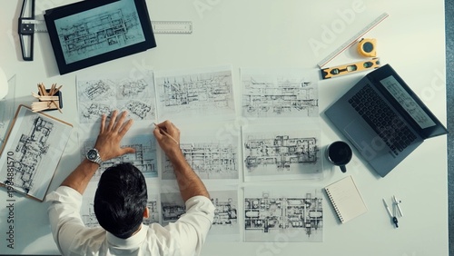 Canvastavla Top down aerial view of architect engineer placing building blueprint on table while checking and choosing project plan