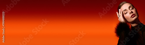 Valokuva Elegant young woman poses against a vibrant orange backdrop, radiating confidenc