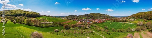A bird's-eye view of the Taunus landscape awakening in spring, with blossoming trees and yellow rapeseed fields.