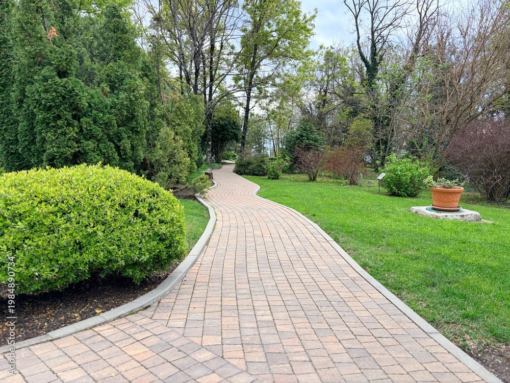 Obraz premium path in the park. Beautiful landscape design. Concrete tiles path in the spring park.