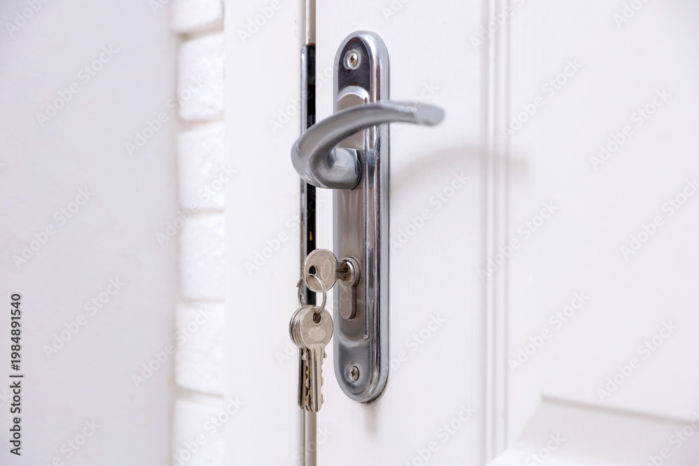 Fototapeta premium Door with keys and metal handle indoors, closeup