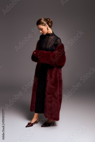 Fotografija Sophisticated young woman embodies elegance in a chic burgundy ensemble and striking shoes