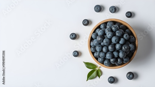 Abundant fresh blueberries in a woven basket with scattered berries and leaves