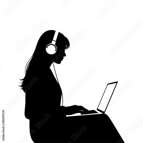 A woman in silhouette works on her laptop while listening to music with headphones on
