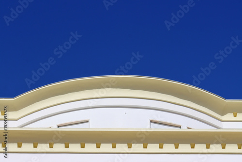 Fotografía Elegant architectural detail with a curved classical facade against a clear deep blue sky, ideal for urban design, travel themes, and building exterior concepts