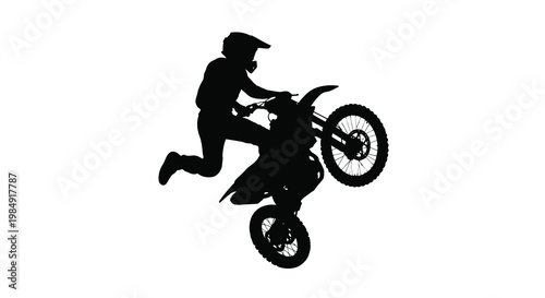 Silhouette of a motocross rider performing a dynamic jump with their bike